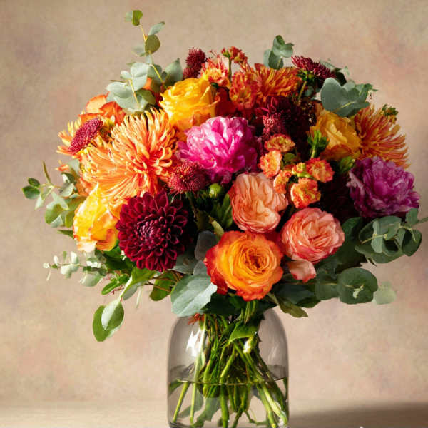 Colorful mixed bouquet of roses and chrysanthemums in a glass vase