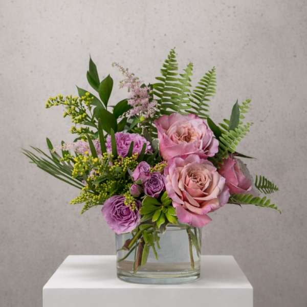 Pink and purple rose bouquet in a clear glass vase