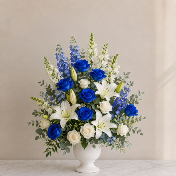 Blue and white roses with white lilies in a white vase