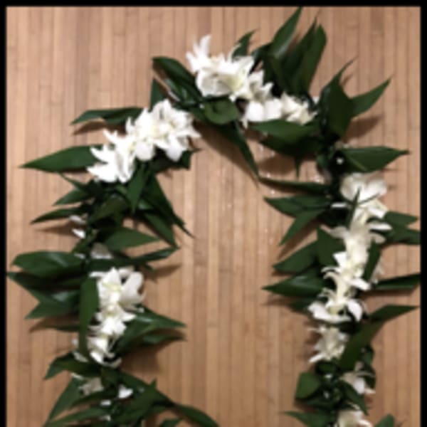 Long white flower lei with large green leaves arranged in an oval shape