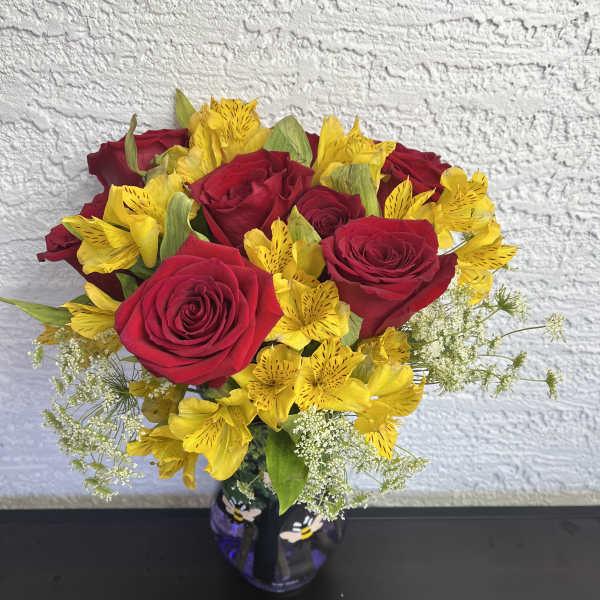 Red roses and yellow alstroemeria in a glass vase