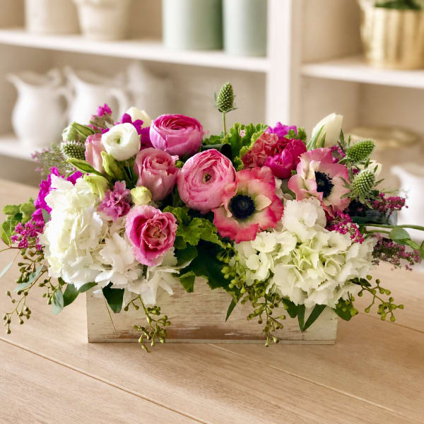 Pink and white mixed flower arrangement in a wooden box