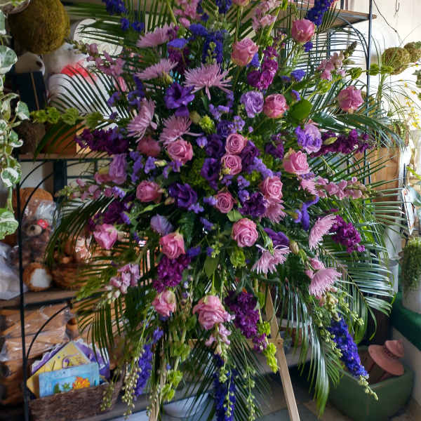 Large standing floral spray with pink and purple flowers on an easel