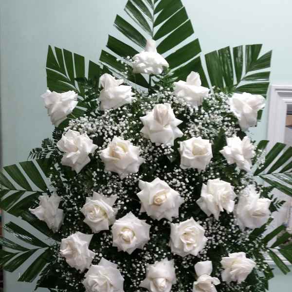 White rose standing spray with large palm leaves and baby's breath