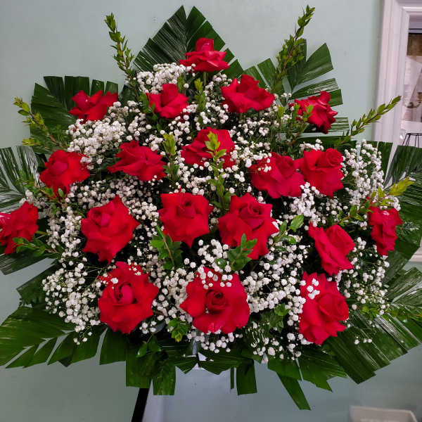Large bouquet of red roses with white baby's breath and palm leaves