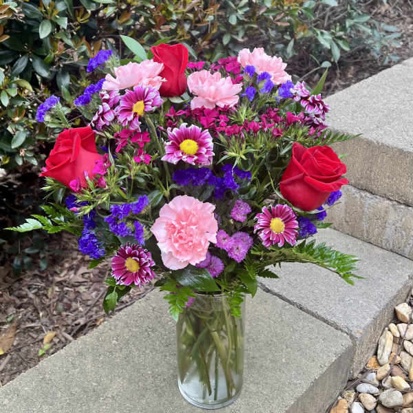 Bouquet of pink and red flowers in a clear glass vase