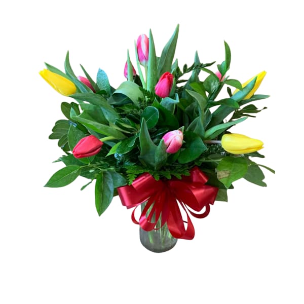 Bouquet of colorful tulips in a glass vase with a red ribbon