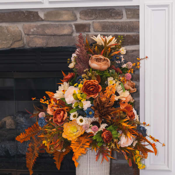 Tall autumn floral arrangement in a white pedestal vase