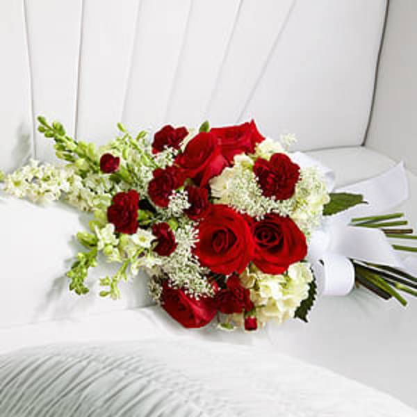 Red roses and white flowers arranged in a white chair