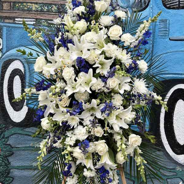 Tall white and blue floral standing spray on an easel