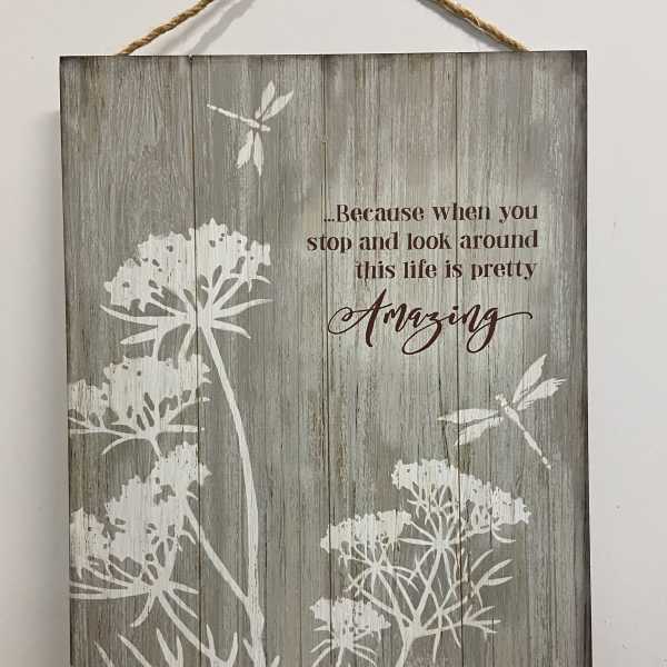 Rustic wood wall sign with white floral silhouettes, dragonflies, and an inspirational quote.