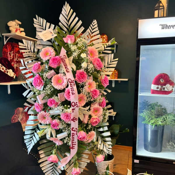 Pink rose and daisy standing spray with a memorial ribbon
