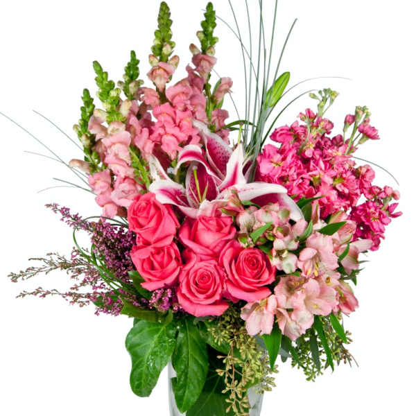 Pink roses and lilies arranged in a clear glass vase