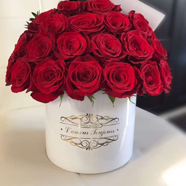 Red roses arranged in a white hatbox