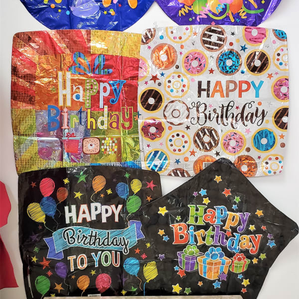 Assorted birthday balloons with colorful printed designs and messages