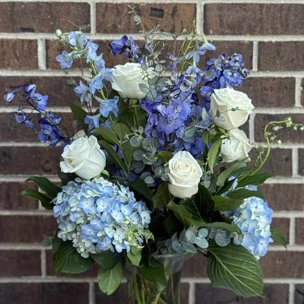 Blue and white floral arrangement in a glass vase
