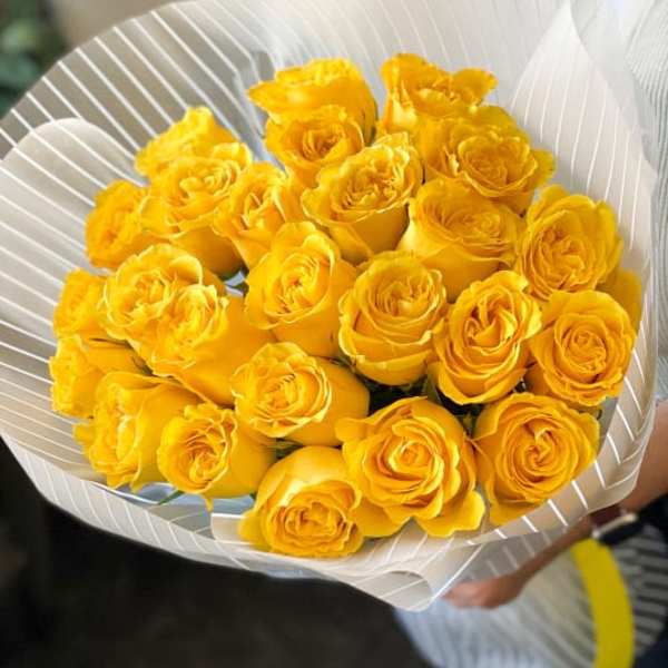 Bouquet of yellow roses wrapped in white paper