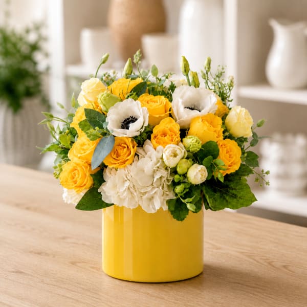 Yellow and white flower arrangement in a yellow vase
