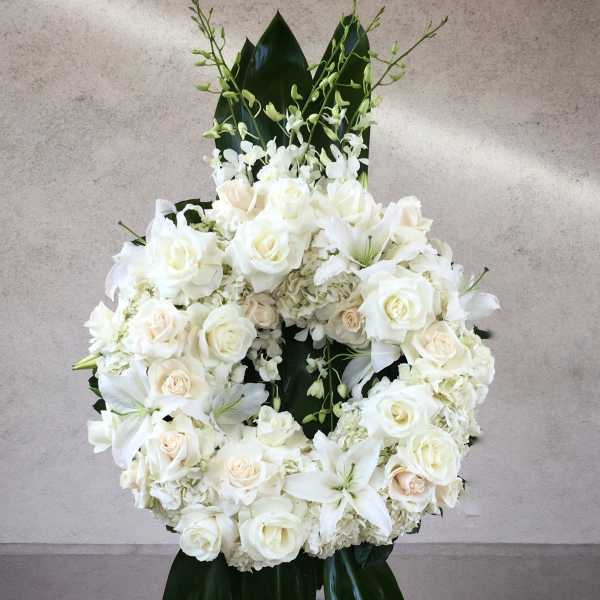White rose and lily wreath with dark green leaves