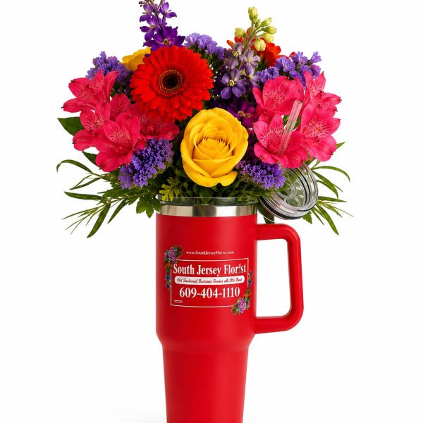 Bright mixed bouquet in a red handled tumbler with a clear lid