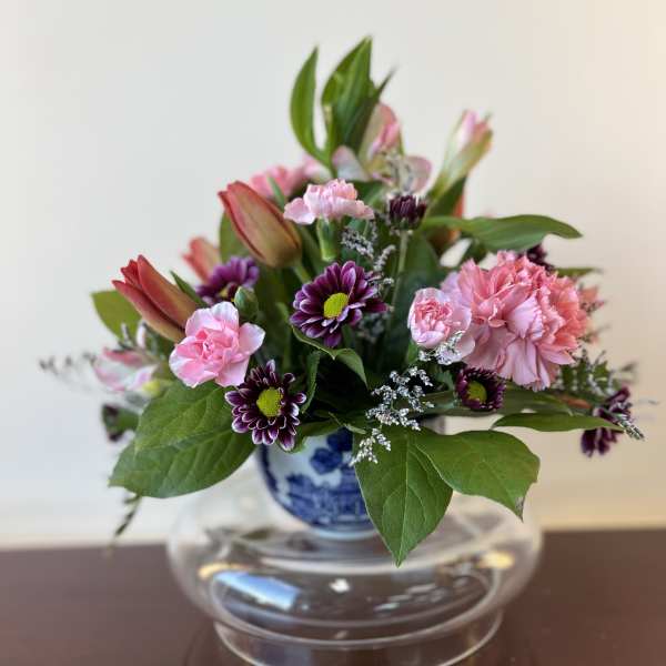 Pink and purple mixed bouquet in a blue-and-white vase