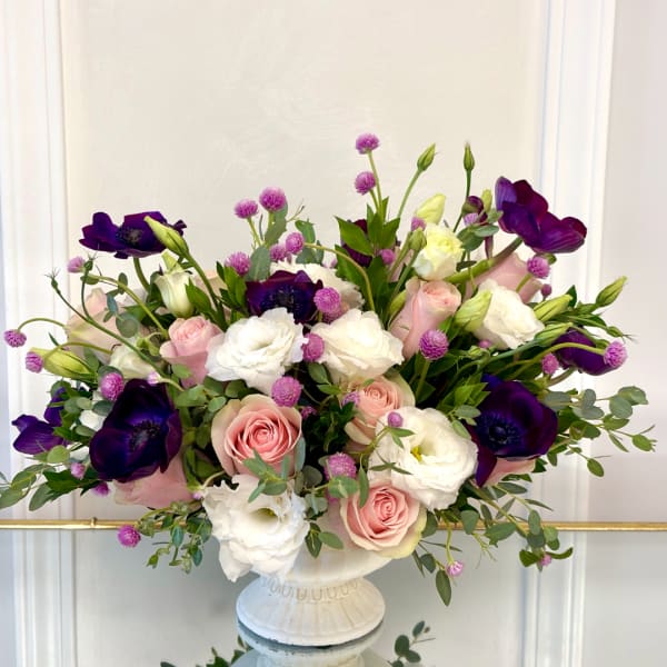 Pink and white roses with purple anemones in a white vase