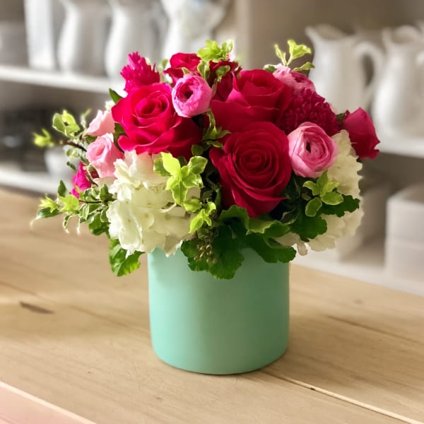Pink and white roses in a mint green vase