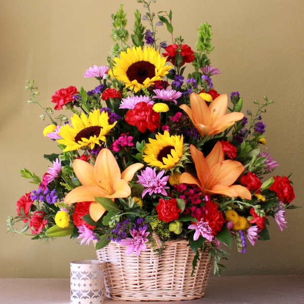 Basket arrangement with sunflowers, lilies, and mixed blooms