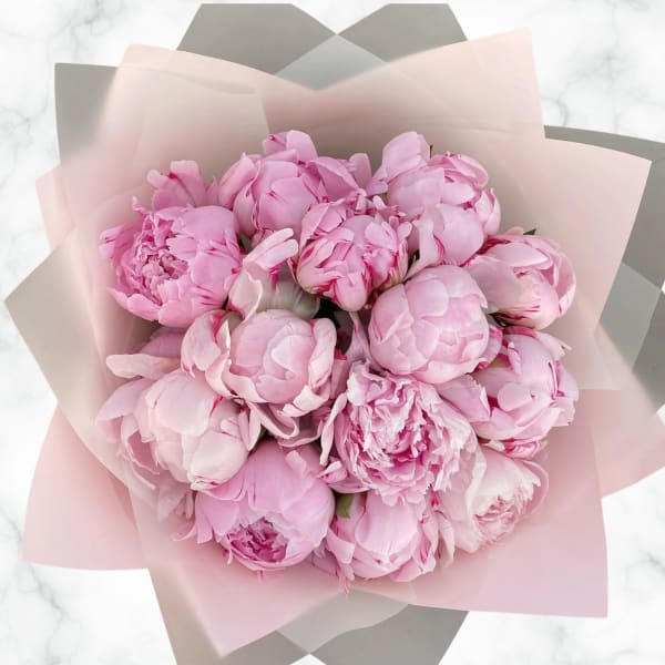 Bouquet of pink peonies wrapped in pale pink paper