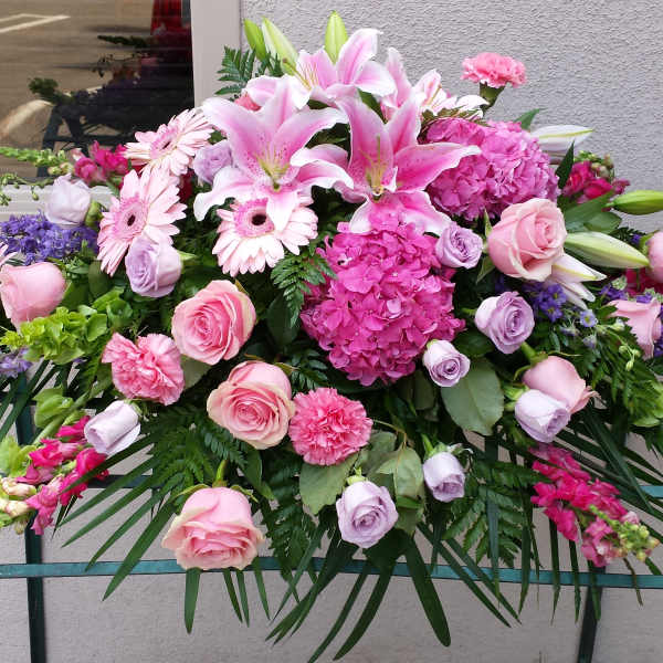 Large pink and purple floral arrangement with lilies, roses, and hydrangeas