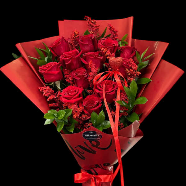 Bouquet of red roses wrapped in red paper with a ribbon