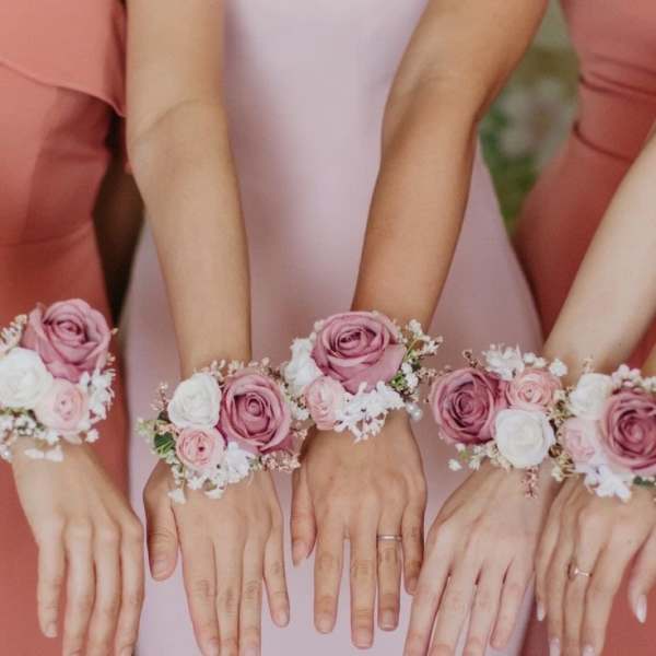 Bridesmaids wearing pink rose wrist corsages