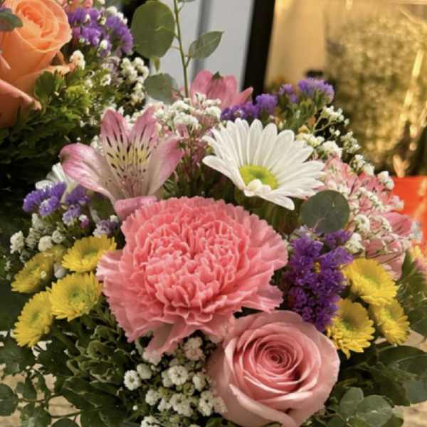 Mixed bouquet in a notebook-style vase with pink and white flowers