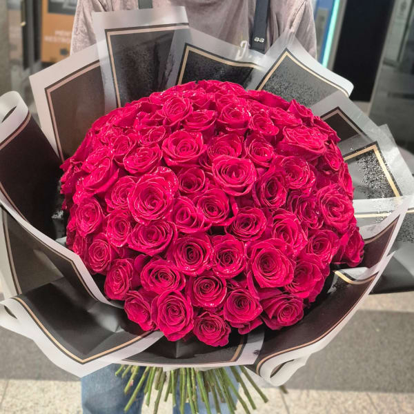 Large bouquet of hot pink roses wrapped in black and white paper