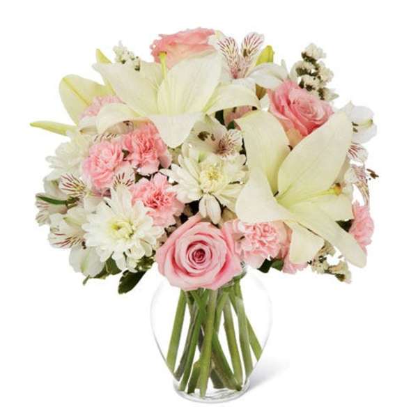 Pink roses and white lilies in a clear glass vase