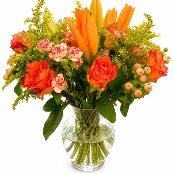 Orange lilies and roses in a clear glass vase