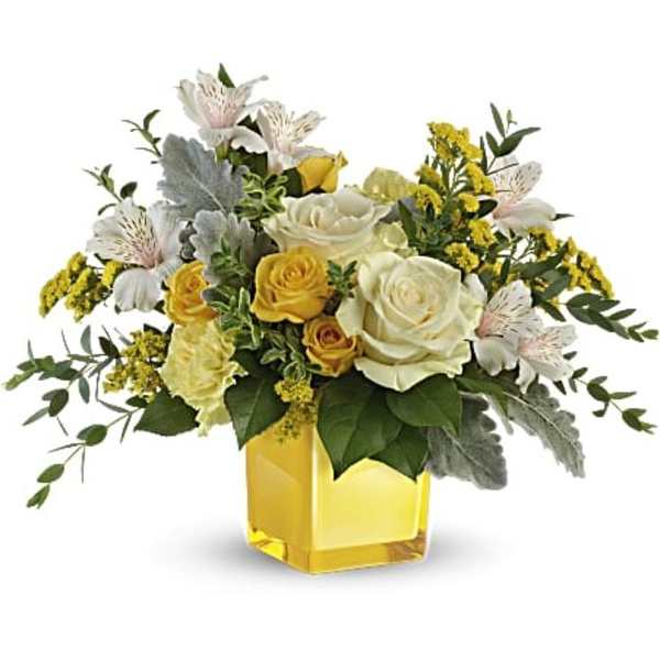 Yellow and white rose arrangement in a square glass vase