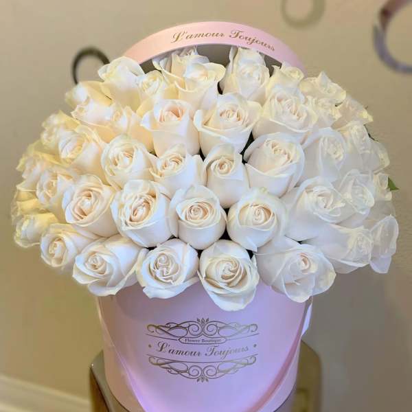 Bouquet of white roses in a pink hatbox