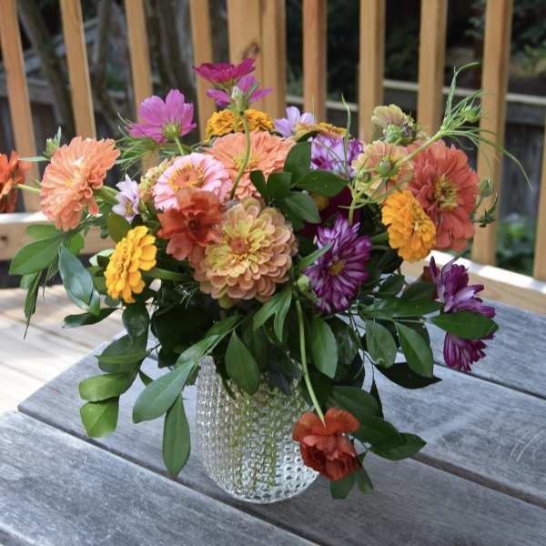 Mixed bouquet of colorful flowers in a clear glass vase