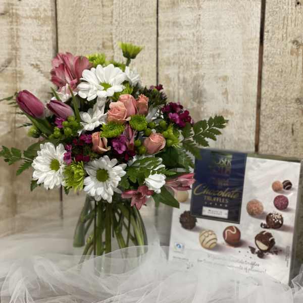 Mixed bouquet of pink roses and white daisies in a glass vase