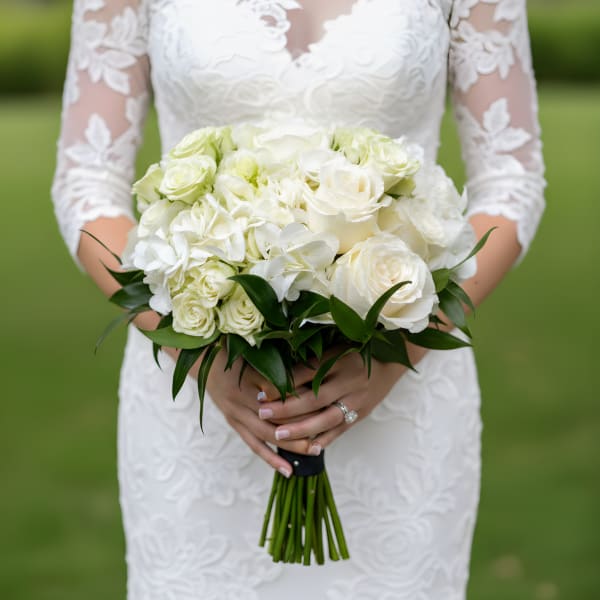 Bride holding a white rose and hydrangea bouquet