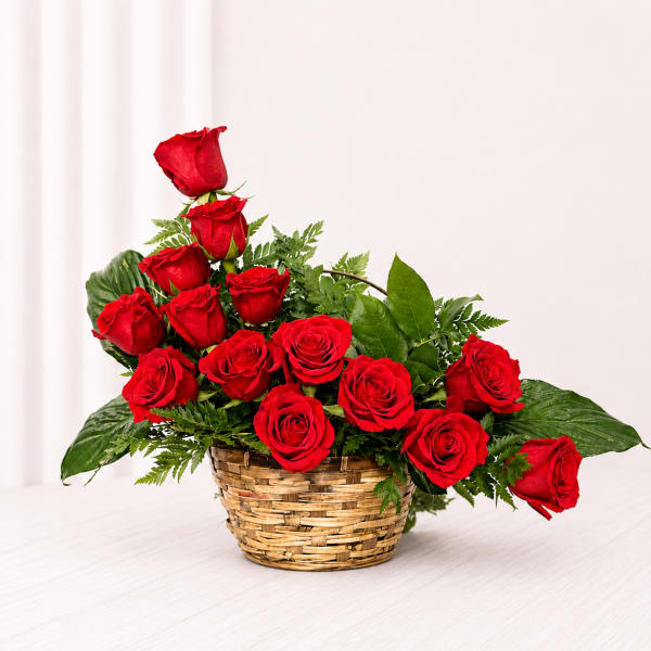 Basket arrangement of red roses with greenery