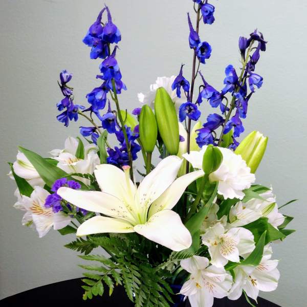 Blue and white flower arrangement in a tall cobalt vase