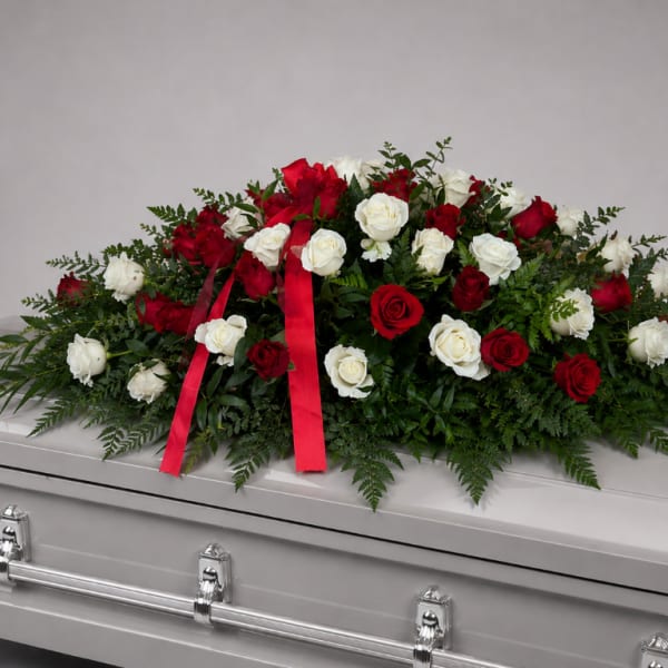 Red and white rose spray on a silver casket