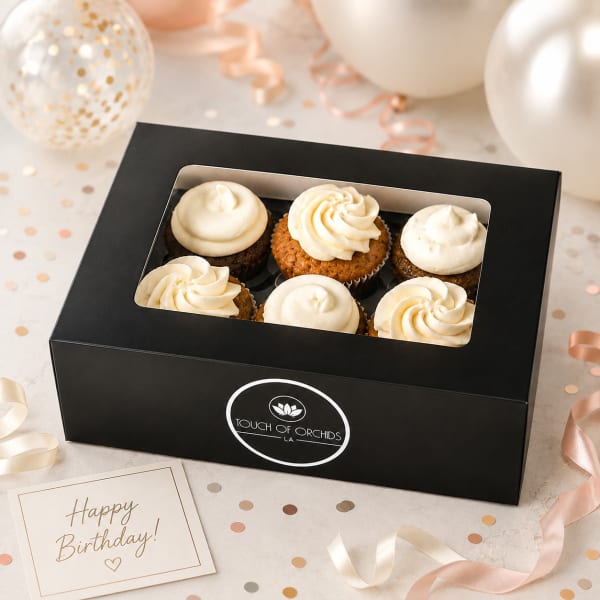 Box of frosted cupcakes with a birthday card and ribbon decorations
