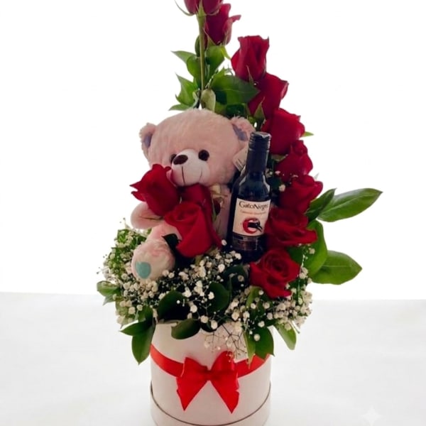 Red roses with a teddy bear and wine bottle in a white hatbox