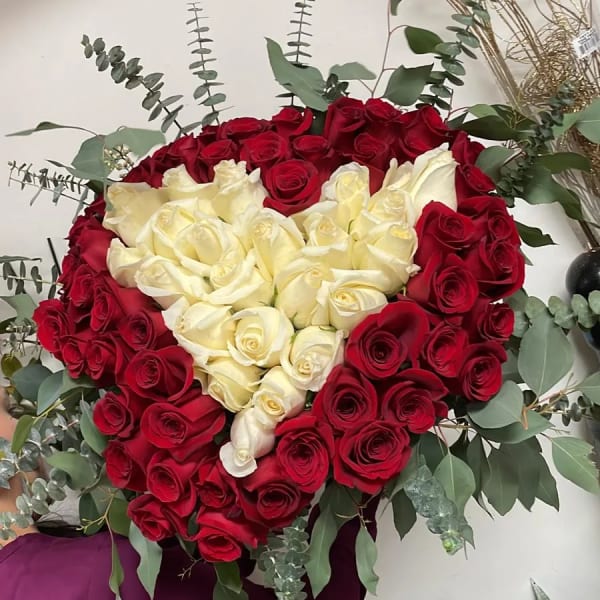 Heart-shaped bouquet of red and white roses with eucalyptus