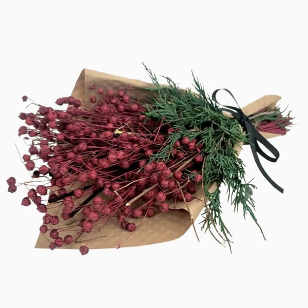 Bundle of red dried flowers wrapped in brown paper with a black ribbon