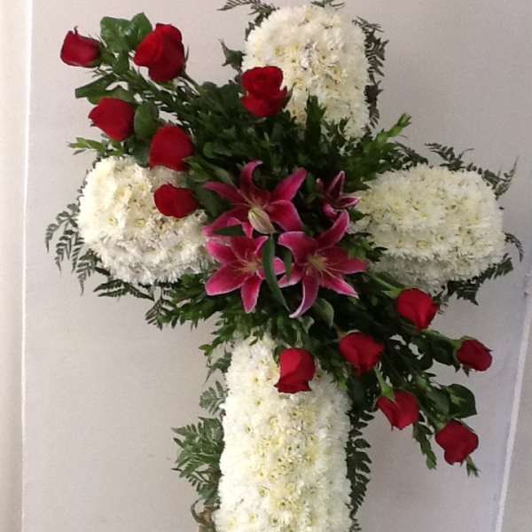 Cross-shaped floral standing spray with white blooms, red roses, and pink lilies