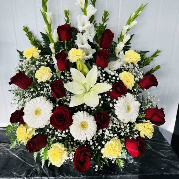 Large red rose and white lily arrangement with yellow carnations and white daisies
